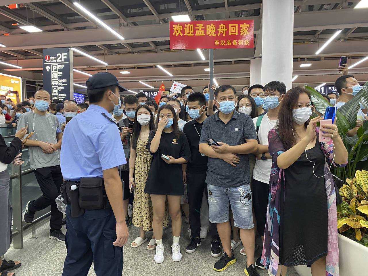Police stand guard as supporters of Huawei CFO Meng Wanzhou gather at Shenzhen Bao'an International...