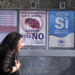 
              A woman walks past posters for the abortion referendum in San Marino, Sunday, Sept. 26, 2021. Tiny San Marino is one of the last countries in Europe which forbids abortion in any circumstance — a ban that dates from 1865. Its citizens are voting Sunday in a referendum calling for abortion to be made legal in the first 12 weeks of pregnancy. (AP Photo/Antonio Calanni)
            
