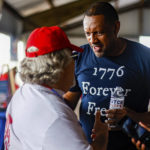 
              FILE - Georgia gubernatorial candidate Vernon Jones speaks to an attendee of the 17th annual Floyd County GOP Rally at the Coosa Valley Fairgrounds on Saturday, Aug. 7, 2021 in Rome, Ga.  The rewards of an early Donald Trump endorsement will be on display Saturday, Sept. 25  in Georgia. A three-man ticket of candidates he’s backing in 2022 Republican primaries for statewide office will take the stage with him. (Troy Stolt/Chattanooga Times Free Press via AP)
            