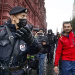 
              Police escort a demonstrator with a red flag during a protest against the results of the Parliamentary election near Red Square in Moscow, Russia, Saturday, Sept. 25, 2021. The Communist Party has called for a rally in Moscow on Saturday and was urged by the authorities Friday to remove the announcements from its website, otherwise it would be blocked — pressure that a party with seats in the parliament and which backs many of the Kremlin's policies has rarely faced before. (AP Photo/Vasily Krestyaninov)
            