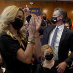 
              Gov. Gavin Newsom, middle right, gestures next to his wife, Jennifer Siebel Newsom, foreground, and their daughter, Brooklynn, bottom, after speaking to volunteers in San Francisco, Tuesday, Sept. 14, 2021. The recall election that could remove California Democratic Gov. Newsom is coming to an end. Voting concludes Tuesday in the rare, late-summer election that has emerged as a national battlefront on issues from COVID-19 restrictions to climate change. (AP Photo/Jeff Chiu)
            