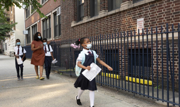 A girl leads her mother and brothers as they arrive at Brooklyn's PS 245, Monday, Sept. 13, 2021, i...