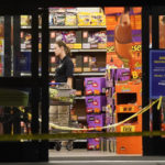 
              A responder walks down an aisle in a Kroger grocery store as the investigation goes into the night following a shooting earlier in the day on Thursday, Sept. 23, 2021, in Collierville, Tenn. Police say a gunman attacked people in the store and killed at least one person and wounded 12 others before the suspect was found dead. (AP Photo/Mark Humphrey)
            