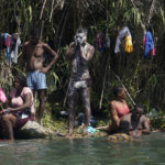 
              Haitian migrants bathe and do laundry along the banks of the Rio Grand after they crossed into the United States from Mexico, Saturday, Sept. 18, 2021, in Del Rio, Texas. The U.S. plans to speed up its efforts to expel Haitian migrants on flights to their Caribbean homeland, officials said Saturday as agents poured into a Texas border city where thousands of Haitians have gathered after suddenly crossing into the U.S. from Mexico. (AP Photo/Eric Gay)
            