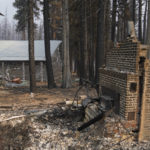 
              FILE - In this Sept. 2, 2021 file photo a cabin partially covered in fire-resistant material stands next to properties destroyed in the Caldor Fire in Twin Bridges, Calif. Aluminum wraps designed to protect homes from flames are getting attention as wildfires burn in California.  (AP Photo/Jae C. Hong,File)
            