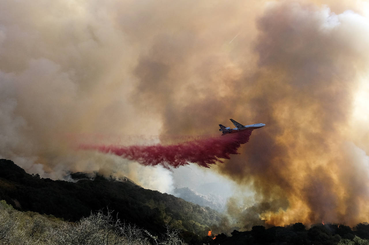 An air tanker drops retardant on a wildfire Wednesday, Oct. 13, 2021, in Goleta, Calif. A wildfire ...