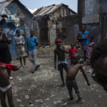 
              Neighbors gather outside their homes built with recycled metal sheets in the Bellecour-Cite Soleil shanty town of Port-au-Prince, Haiti, Friday, Oct. 1, 2021. Bellecour-Cité Soleil, a neighborhood of tin shacks without water, electricity or any basic services, is the stronghold of Jimmy Cherizier, aka Barbecue, a former policeman who leads the G9 gang coalition. (AP Photo/Rodrigo Abd)
            