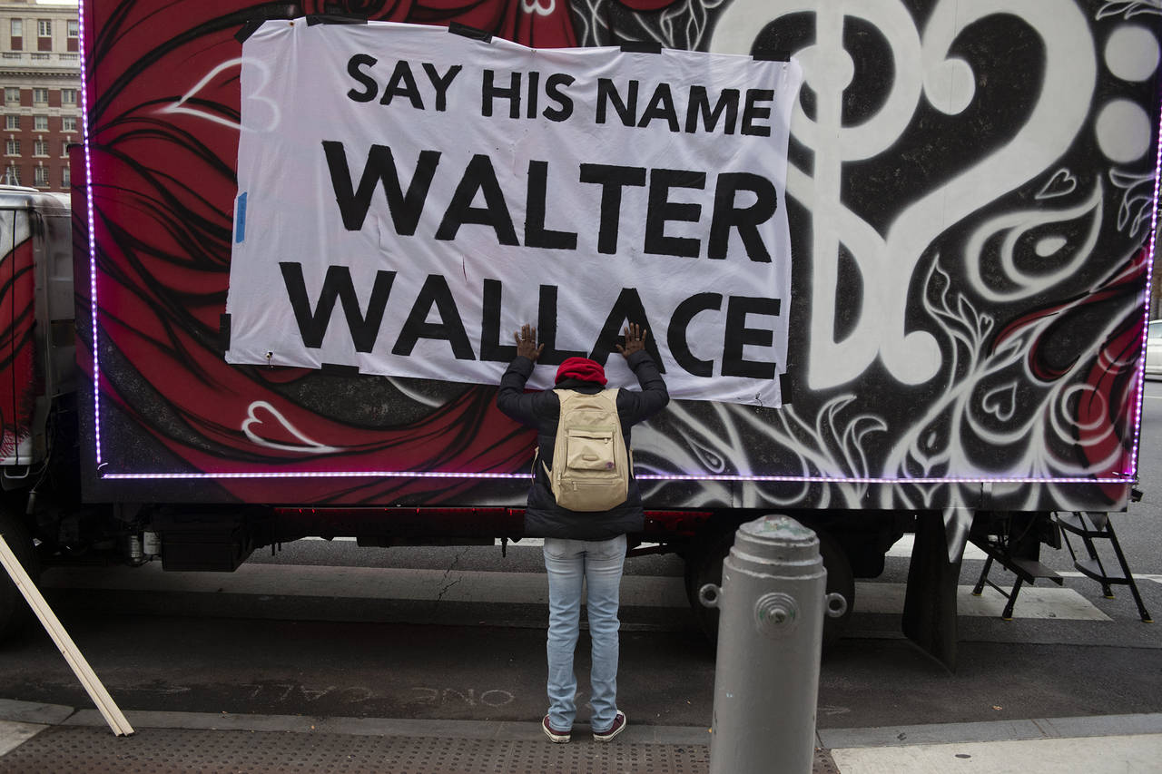 FILE - In this Nov. 4, 2020, file photo, Sheila Rhames rests her hands on a banner honoring Walter ...