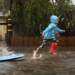 
              A child runs through floodwaters on Robin Road in Mill Valley, Calif., on Sunday, Oct. 24, 2021. (AP Photo/Ethan Swope)
            