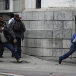 
              Protesters throw stones at police during a protest of veterans demanding that a law be passed that compensates them for having served during the country's civil war, outside the Congress building in Guatemala City, Tuesday, Oct. 19, 2021. (AP Photo/Moises Castillo)
            