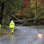 
              Crew members of the North Attleboro Electric Dept. survey the damage done by a toppled tree that took down utility lines as a primary line arcs on Reservoir Street in North Attleboro, Mass. Wednesday, Oct. 27, 2021. A nor'easter rain and wind system blanketed the region overnight Tuesday into Wednesday. (Mark Stockwell/The Sun Chronicle via AP)
            