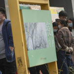 
              Residents wearing face masks to help curb the spread of the coronavirus line up to receive booster shots against COVID-19 at a vaccination site displaying a poster baring the words: "Epidemic protection" in Beijing, Monday, Oct. 25, 2021. A northwestern Chinese province heavily dependent on tourism closed all tourist sites Monday after finding new COVID-19 cases. (AP Photo/Andy Wong)
            