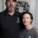 In this Oct. 12, 2021, photo, David and Wendy Mills, parents of Kailee Mills who was killed four years ago in an automobile accident when riding in the back seat without a seat belt, with a photo of their daughter at their home in Spring, Texas. The teenager was riding in the back seat of a car to a Halloween party in 2017 just a mile from her house when she unfastened her seat belt to slide next to her friend and take a selfie. Moments later, the driver veered off the road and the car flipped, ejecting her. (AP Photo/Michael Wyke)