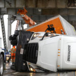
              Crews work to upright an overturned semi-tractor-trailer truck on the Richmond-San Rafael Bridge in Richmond, Calif., on Sunday, Oct. 24, 2021. An atmospheric river storm, the strongest to hit the Bay Area in two years, moved through the Bay Area on Sunday. (Anda Chu/Bay Area News Group via AP)
            