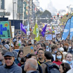 
              Protestors hold signs as they participate in a climate march and demonstration in Brussels, Sunday, Oct. 10, 2021. Some 80 organizations are joining in a climate march through Brussels to demand change and push politicians to effective action in Glasgow later this month.(AP Photo/Geert Vanden Wijngaert)
            