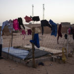 
              A Sahrawi refugee girl picks-up the laundry in the Boujdour refugee camp, Algeria, Friday, Oct. 15, 2021. (AP Photo/Bernat Armangue)
            