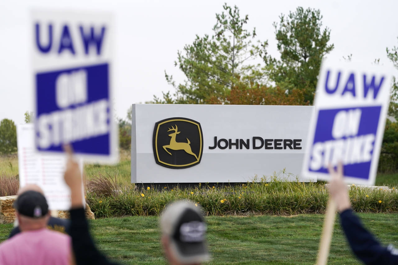 FILE - Members of the United Auto Workers strike outside of a John Deere plant, Wednesday, Oct. 20,...