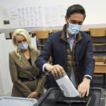 
              Kosovo Democratic Party (PDK) candidate for mayor, Uran Ismaili, flanked by his wife Arizona Ismaili, left, casts his ballot at a polling station in Pristina, Kosovo, Sunday, Oct. 17, 2021. Kosovo is holding municipal elections Sunday in which the eight-month-old leftwing governing party aims at capturing the capital Pristina's city hall. (AP Photo/Visar Kryeziu)
            