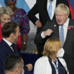 
              British Prime Minister Boris Johnson, center, pumps fists with French President Emmanuel Macron, left, during a group photo with medical personnel at the La Nuvola conference center for the G20 summit in Rome, Saturday, Oct. 30, 2021. The two-day Group of 20 summit is the first in-person gathering of leaders of the world's biggest economies since the COVID-19 pandemic started. (AP Photo/Kirsty Wigglesworth, Pool)
            