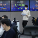 
              A currency trader passes by screens showing the Korea Composite Stock Price Index (KOSPI), left, and the foreign exchange rate between U.S. dollar and South Korean won, center, at the foreign exchange dealing room of the KEB Hana Bank headquarters in Seoul, South Korea, Thursday, Oct. 14, 2021. Asian shares were mostly higher on Thursday, tracking an overnight rally on Wall Street as investors sought out bargains, including technology stocks. (AP Photo/Ahn Young-joon)
            