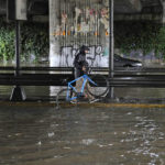 
              A man carries his bicycle as walks under a flooded underpass, in Athens, Thursday, Oct. 14, 2021. Storms battered the Greek capital and other parts of southern Greece, causing traffic disruption and some road closures. (AP Photo/Thanassis Stavrakis)
            