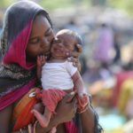 
              Aameen, a migrant laborer, holds her fifteen-day-old daughter Aradhana, as she waits at a railway station to return to her hometown, in Jammu, India, Thursday, Oct. 21, 2021. Indian-controlled Kashmir has witnessed a major rise in violence targeting Indian civilians who hail from outside of the disputed Himalayan region. (AP Photo/Channi Anand)
            