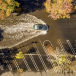 
              A car crosses a flooded parking lot in Oroville, Calif., on Monday, Oct. 25, 2021. A massive storm barreled toward Southern California on Monday after causing flooding across the northern half of the state. (AP Photo/Noah Berger)
            