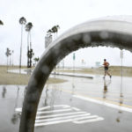 
              Wet weather is no barrier for joggers along the bike path in Long Beach, Calif., Monday, Oct. 25, 2021. (Brittany Murray/The Orange County Register via AP)
            