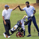 
              North Carolina A&T head golf coach Richard Watkins, left, bumps fists with and North Carolina A&T's J.R. Smith on the ninth hole during the second round of the Phoenix Invitational golf tournament in Burlington, N.C., Tuesday, Oct. 12, 2021. Smith spent 16 years playing in the NBA, winning two world championships. (Woody Marshall/News & Record via AP)
            