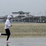 
              Wet weather is no barrier for joggers along the bike path in Long Beach, Calif., on Monday, Oct 25, 2021. (Brittany Murray/The Orange County Register via AP)
            