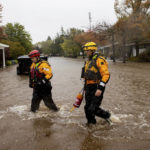 
              Santa Rosa firefighters check for residents trapped by floodwaters on Neotomas Avenue in Santa Rosa, Calif., on Sunday, Oct. 24, 2021. (AP Photo/Ethan Swope)
            