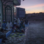
              Members of the Sufi Karkariya order pray the sunset Maghreb prayer during a religious celebration of the birthday of the prophet Muhammed, in Aroui, near Nador, eastern Morocco, Monday, Oct. 18, 2021. It was the first such gathering since the pandemic. The order, the Karkariya, follows a mystical form of Islam recognizable by its unique dress code: A modest yet colorful patchwork robe.(AP Photo/Mosa'ab Elshamy)
            