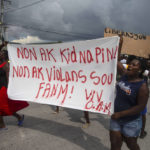 
              People protest carrying a banner with a message that reads in Creole: "No to kidnappings, no to violence against women ! Long live Christian Aid Ministries,"  demanding the release of kidnapped missionaries, in Titanyen, north of Port-au-Prince, Haiti, Tuesday, Oct. 19, 2021. A group of 17 U.S. missionaries including children was kidnapped by a gang in Haiti on Oct. 16. (AP Photo/Joseph Odelyn)
            