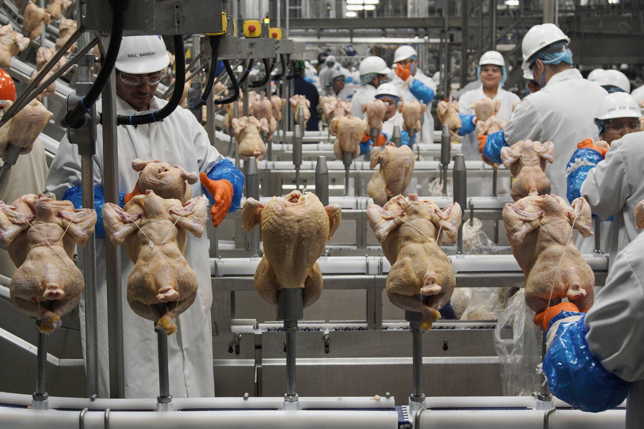 FILE - In this Dec. 12, 2019, file photo workers process chickens at a poultry plant, in Fremont, N...