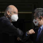 
              Greece's Foreign Minister Nikos Dendias, left, and his Chinese counterpart Wang Yi touch elbows and wear protective face masks to curb he spread of COVID-19 prior to their meeting, in Athens, on Wednesday, Oct. 27, 2021. (AP Photo/Petros Giannakouris)
            
