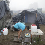 
              A migrant man washes his face at a makeshift camp housing migrants mostly from Afghanistan, in Velika Kladusa, Bosnia, Tuesday, Oct. 12, 2021. Hundreds of migrants _ including small children, babies and elderly people _ have set up a new improvised camp in northwest Bosnia, determined to brave worsening weather and tough Croatian border police for a chance to reach Western Europe.(AP Photo)
            