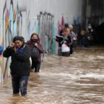 
              Passengers wade through high water after evacuating a bus stuck in a flooded underpass in southern Athens, Thursday, Oct. 14, 2021. Storms have been battering the Greek capital and other parts of southern Greece, causing traffic disruption and some road closures. (AP Photo/Thanassis Stavrakis)
            