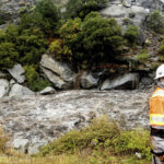 
              Caltrans maintenance supervisor Matt Martin surveys a landslide covering Highway 70 in the Dixie Fire zone on Sunday, Oct. 24, 2021, in Plumas County, Calif. Heavy rains blanketing Northern California created slide and flood hazards in land scorched during last summer's wildfires. (AP Photo/Noah Berger)
            