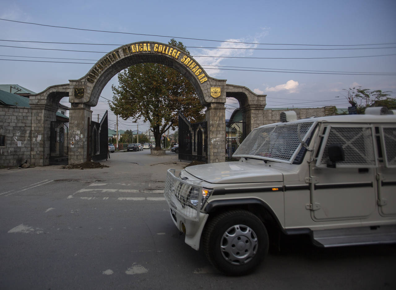 A paramilitary vehicle passes the front gate of Government Medical College in Srinagar, Indian cont...
