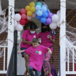 
              In this Saturday, Oct. 16, 2021, photo Han Jones, left, and Lucy Hartman, right, of Planned Parenthood Advocates of Virginia, along with Henry Pickett, center, leave a porch decorated for Halloween as they canvass the area to encourage voters to vote in Richmond, Va. (AP Photo/Steve Helber)
            