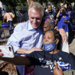 
              Democratic gubernatorial candidate, former Virginia Gov. Terry McAuliffe, left, poses for a photo with supporters after a rally in Norfolk, Va., Sunday, Oct. 17, 2021. Abrams was in town to encourage voters to vote for Democratic gubernatorial candidate Terry McAuliffe in the November election. (AP Photo/Steve Helber)
            