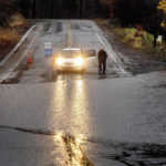 
              A motorist surveys floodwaters from Lake Madrone crossing Oro Quincy Highway on Sunday, Oct. 24, 2021, in Butte County, Calif. The area burned in 2020's North Complex Fire. (AP Photo/Noah Berger)
            