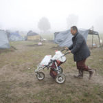 
              A migrant man carries drinking water in a baby stroller at a makeshift camp housing migrants mostly from Afghanistan, in Velika Kladusa, Bosnia, Tuesday, Oct. 12, 2021. (AP Photo)
            