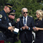 
              President Joe Biden and first lady Jill Biden speak to Jimmy Holderfield, National Secretary of the Fraternal Order of Police, second from left, and James Smallwood, National Treasurer of the National Fraternal Order of Police, left, as they are to place flowers on a wreath during a ceremony honoring fallen law enforcement officers at the 40th annual National Peace Officers' Memorial Service at the U.S. Capitol in Washington, Saturday, Oct. 16, 2021. (AP Photo/Manuel Balce Ceneta)
            