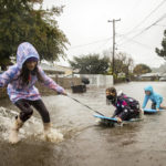 
              Children play in floodwaters on Robin Road in Mill Valley, Calif., on Sunday, Oct. 24, 2021. (AP Photo/Ethan Swope)
            