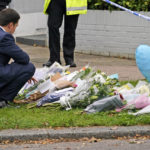 
              A man leaves flowers on the road leading to the Belfairs Methodist Church in Eastwood Road North, in Leigh-on-Sea, Essex, England, Saturday, Oct. 16, 2021. David Amess, a long-serving member of Parliament was stabbed to death during a meeting with constituents at a church in Leigh-on-Sea on Friday, in what police said was a terrorist incident. A 25-year-old man was arrested in connection with the attack, which united Britain's fractious politicians in shock and sorrow. (AP Photo/Alberto Pezzali)
            