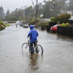 
              A person bikes through floodwaters in Mill Valley, Calif., on Sunday, Oct. 24, 2021. (AP Photo/Ethan Swope)
            