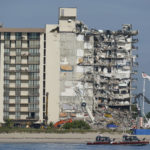 
              FILE - In this July 1, 2021, file photo, Coast Guard boats patrol in front of the partially collapsed Champlain Towers South condo building in Surfside, Fla. A judge pushed on Wednesday, Oct. 20, 2021, for compromise on potential payouts between people who lost loved ones and those whose units were destroyed in the deadly collapse of a Florida beachfront condominium.  (AP Photo/Mark Humphrey, File)
            