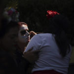 
              A woman has her face painted as a "Catrina" during Day of the Dead festivities in Mexico City, Sunday, Oct. 31, 2021. Altars and artwork from around the country were on display in a parade, as Mexicans honor the Day of the Dead. (AP Photo/Fernando Llano)
            