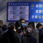 
              A group of women wearing face masks to help curb the spread of the coronavirus use their smartphone to make appointment as residents line up to receive booster shots against COVID-19 at a vaccination site near a residential area in Beijing, Friday, Oct. 22, 2021. China's capital Beijing has begun offering booster shots against COVID-19, four months before the city and surrounding regions are to host the Winter Olympics. (AP Photo/Andy Wong)
            